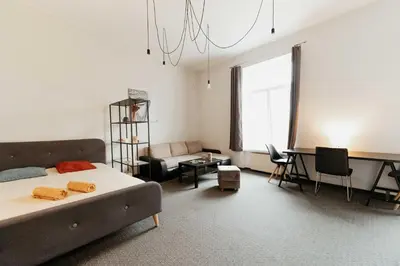 a bedroom with a bed and a desk and a couch at Gedimino Avenue Central Apartment in Vilnius