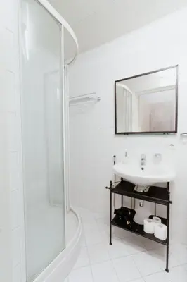 a white bathroom with a sink and a mirror at Gedimino Avenue Central Apartment in Vilnius