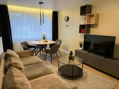 a living room with a couch and a table at Two Bedroom Apartment LAZDYNAI in Vilnius