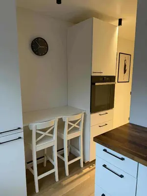 a kitchen with a table and a clock on the wall at Two Bedroom Apartment LAZDYNAI in Vilnius