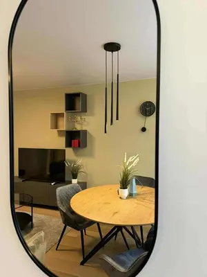 a dining room with a table and chairs and a mirror at Two Bedroom Apartment LAZDYNAI in Vilnius