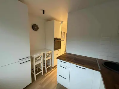 a kitchen with white cabinets and a counter top at Two Bedroom Apartment LAZDYNAI in Vilnius
