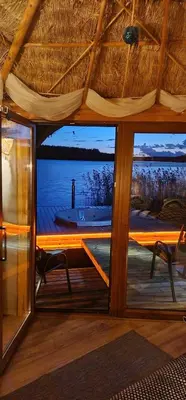 a room with a large window with a view of the water at Lakajų Resort in Molėtai