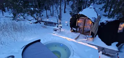 a igloo with a hot tub in the snow at Lakajų Resort in Molėtai