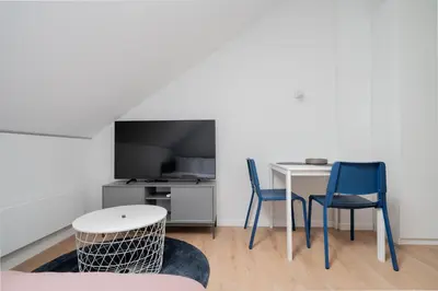 a living room with a table and two chairs at LUMA Apartments by Reside Baltic in Vilnius