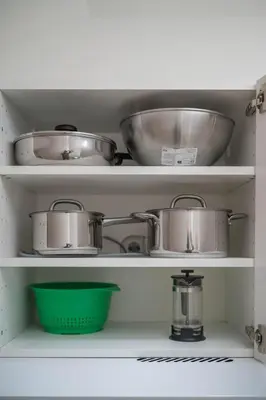 a shelf with pots and pans in a kitchen at LUMA Apartments by Reside Baltic in Vilnius