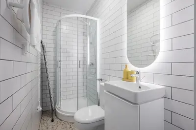 a white bathroom with a sink and a toilet at LUMA Apartments by Reside Baltic in Vilnius