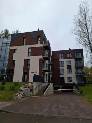 two buildings in a parking lot in front at Ievos apartamentai in Birštonas