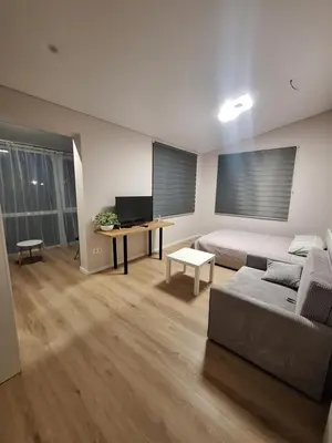 a living room with a couch and a desk at Kambarių nuoma prie Kauno oro uosto in Karmėlava