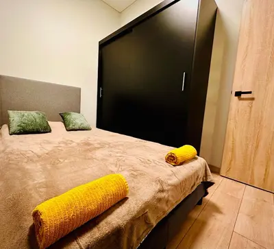 a bedroom with a large bed with yellow pillows at M&M Apartment IV SELF CHECK-IN in Panevėžys