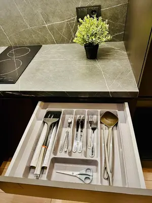 a kitchen sink with silver utensils in a drawer at M&M Apartment IV SELF CHECK-IN in Panevėžys