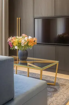 a vase of flowers on a glass table in a living room at Self Check-in Apartment in Vilnius