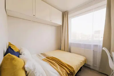 a small bed in a room with a window at Vilnius prie centro ramybė tarp medžių in Vilnius