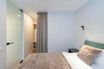 a bedroom with a bed and a sliding glass door at Vytauto 43 Residence – Lietūkis by Domvia in Kaunas