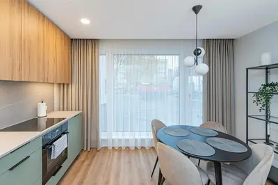 a kitchen and dining room with a table and chairs at Vytauto 43 Residence – Lietūkis by Domvia in Kaunas