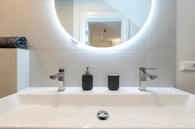 a bathroom with a white sink with a mirror at Vytauto 43 Residence – Lietūkis by Domvia in Kaunas