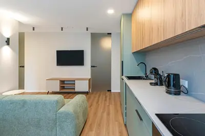 a kitchen with a couch and a television in a room at Vytauto 43 Residence – Lietūkis by Domvia in Kaunas