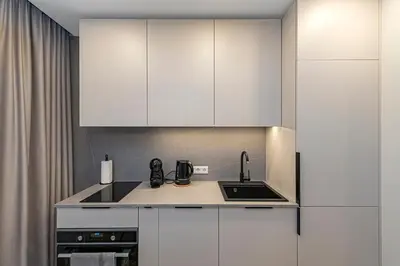 a kitchen with white cabinets and a sink at Vytauto 43 Residence – Lietūkis by Domvia in Kaunas