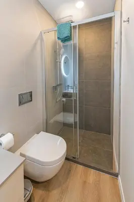 a bathroom with a toilet and a glass shower at Vytauto 43 Residence – Lietūkis by Domvia in Kaunas