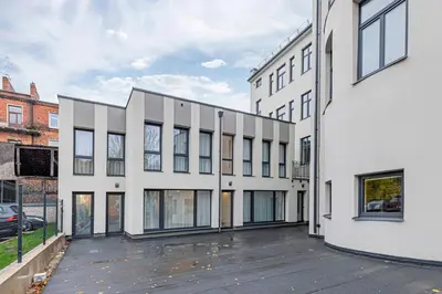an empty parking lot in front of a white building at Vytauto 43 Residence – Lietūkis by Domvia in Kaunas