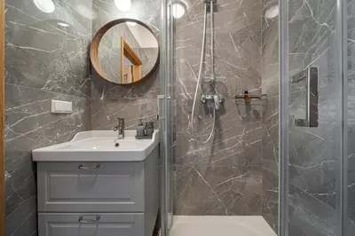 a bathroom with a shower and a sink and a mirror at Bernardinu Boutique in Vilnius