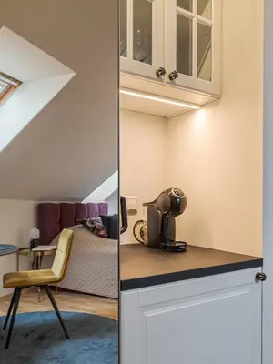 a room with a bed and a kitchen with a microwave at Bernardinu Boutique in Vilnius