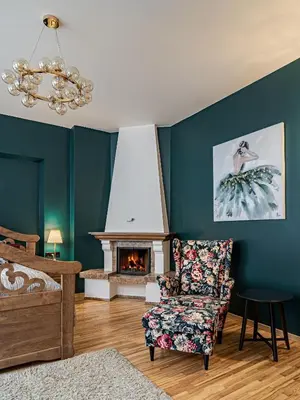 a living room with a chair and a fireplace at Bernardinu Boutique in Vilnius