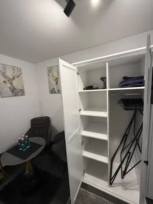 a closet with white shelves and a table in a room at Flat In the heart of Kaunas city center in Kaunas