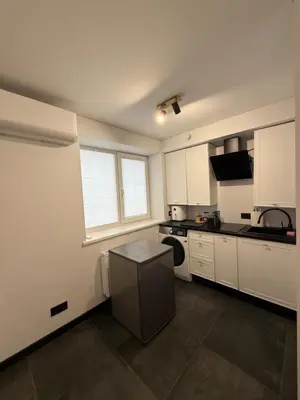a kitchen with white cabinets and a stove top oven at Flat In the heart of Kaunas city center in Kaunas