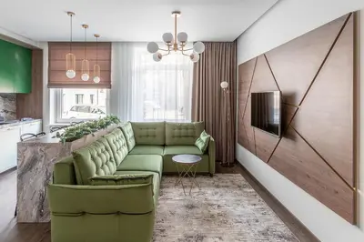 a living room with a green couch and a kitchen at Kaunas old town apartment in Kaunas