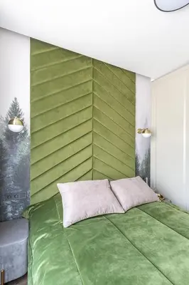 a bedroom with a green wall with a bed at Kaunas old town apartment in Kaunas