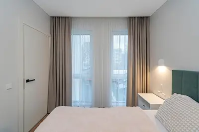 a bedroom with a bed and a large window at Vytauto 43 Residence 3 by Domvia in Kaunas