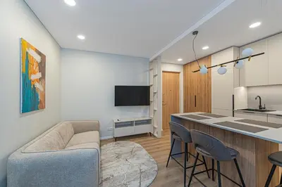 a kitchen and living room with a couch and a bar at Vytauto 43 Residence 4 by Domvia in Kaunas