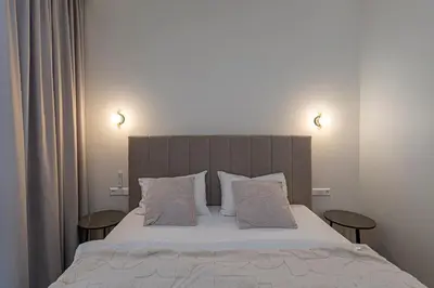 a bedroom with a large bed with two tables at Vytauto 43 Residence 4 by Domvia in Kaunas