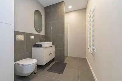 a bathroom with a toilet and a sink and a mirror at Vytauto 43 Residence 4 by Domvia in Kaunas