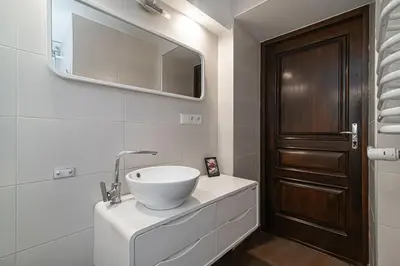 a bathroom with a sink and a wooden door at 1 bedroom apartment in old town with free parking in Vilnius