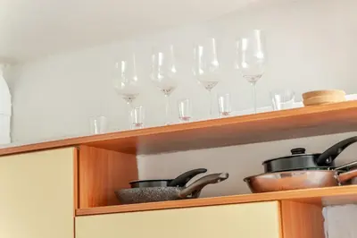 a shelf with wine glasses and pots and pans at Cosy 2 Bed Flat in Naujamiestis in Vilnius