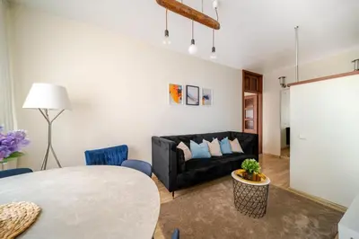 a living room with a black couch and a table at Cosy 2 Bed Flat in Naujamiestis in Vilnius