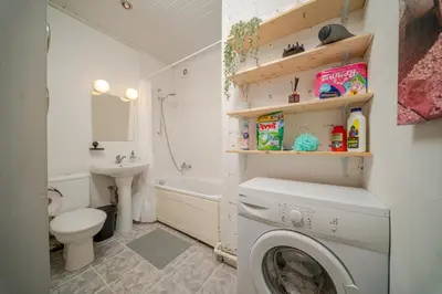 a bathroom with a washing machine and a toilet at Cosy 2 Bed Flat in Naujamiestis in Vilnius