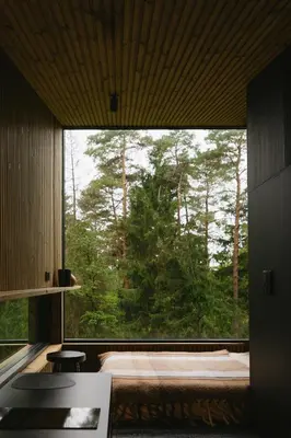 a bedroom with a large window with a bed and trees at Blackview cabin in Kulautuva