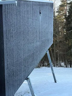 a feeder in the snow with a bird on it at Blackview cabin in Kulautuva