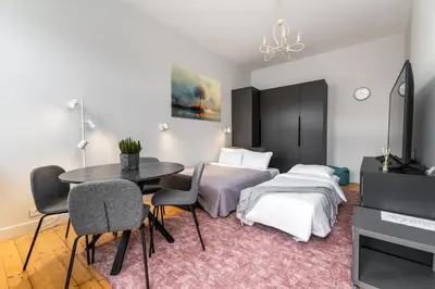 a room with two beds and a table and chairs at Charming Apartment in Kaunas Old Town in Kaunas