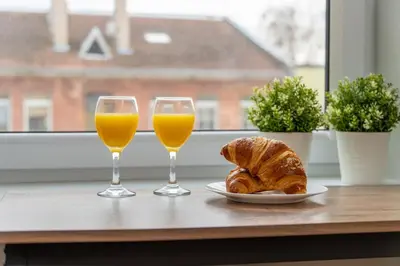 two glasses of orange juice and a plate of croissants at Charming Apartment in Kaunas Old Town in Kaunas