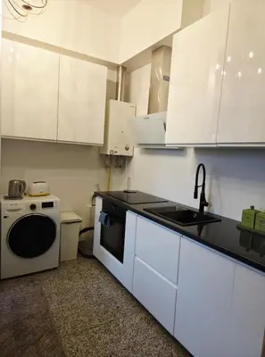 a kitchen with white cabinets and a sink and a dishwasher at Cozy Fryko Era Home - 1929, 2 double beds in Kaunas
