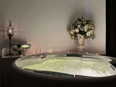 a bath tub with a vase with flowers in it at Host 5 apartment in Kaunas