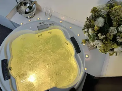 a white sink with a yellow liquid next to a bouquet of flowers at Host 5 apartment in Kaunas