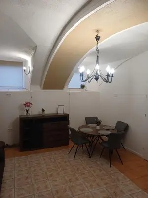 a dining room with a table and a chandelier at Flowers appartments in Vilnius