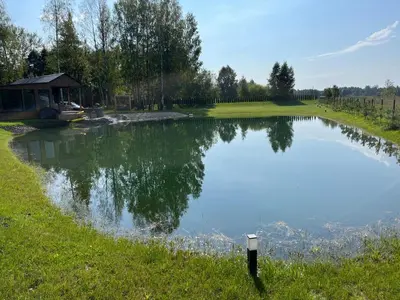 a large pond with a gazebo next to it at Pas Milėją