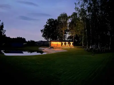 a building with lights in the middle of a field at Pas Milėją