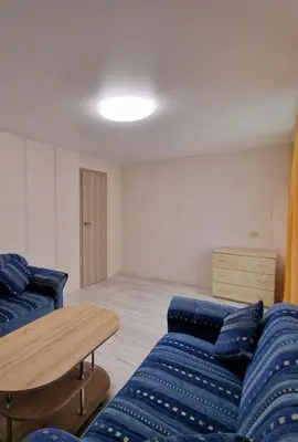 a living room with a blue couch and a table at Pas Dianą 1 aukštas in Jurbarkas